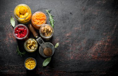 Cam kavanozlarda sebze turşusu. Koyu rustik arka plan üzerinde