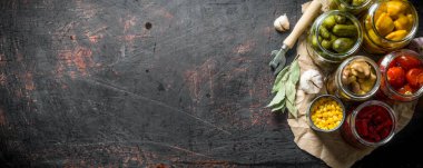 Sarımsak ve Defne yaprağı ile kağıt üzerinde korunmuş sebze. Koyu rustik arka plan üzerinde