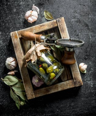 Tahta bir tepsi üzerinde korunmuş salatalık kavanozu. Koyu rustik arka plan üzerinde