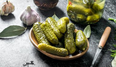 Tabakta korunmuş salatalıklar. Koyu rustik arka plan üzerinde