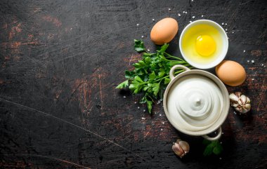 Yumurta, sarımsak ve otlar ile mayonez. Koyu rustik arka plan üzerinde