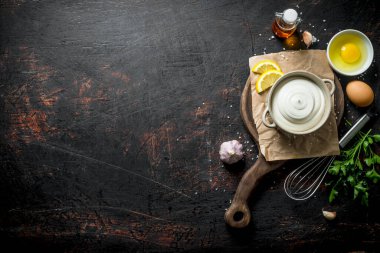 Mayonez yeşillik, yumurta ve yağ ile kesme Kurulu üzerinde. Koyu rustik arka plan üzerinde