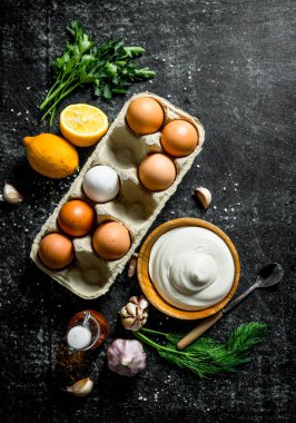 Yumurta, otlar ve sarımsak ile mayonez. Koyu rustik arka plan üzerinde
