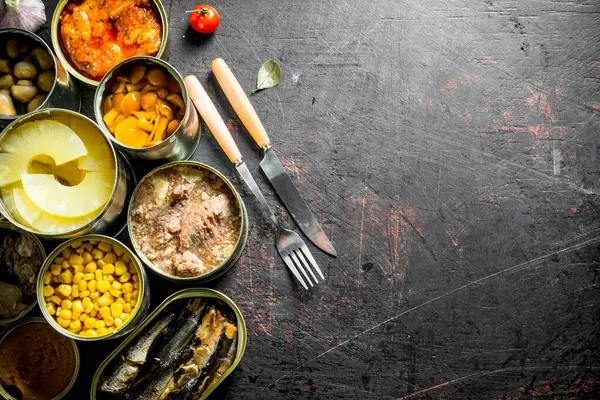 Konserve gıda ile açık konserve konserve grubu. Koyu rustik arka plan üzerinde