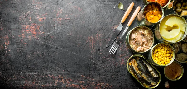 Açık alüminyum konservelerde konserve çeşitleri. Koyu rustik arka plan üzerinde