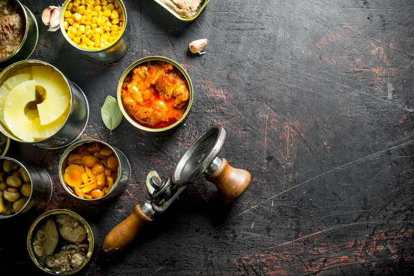 Konservelerde çeşitli konserve ler. Koyu rustik arka plan üzerinde