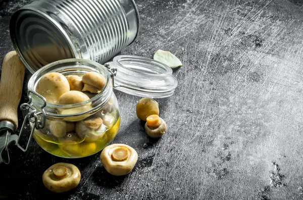 Cam bir kavanozda konserve mantar. Koyu rustik arka plan üzerinde