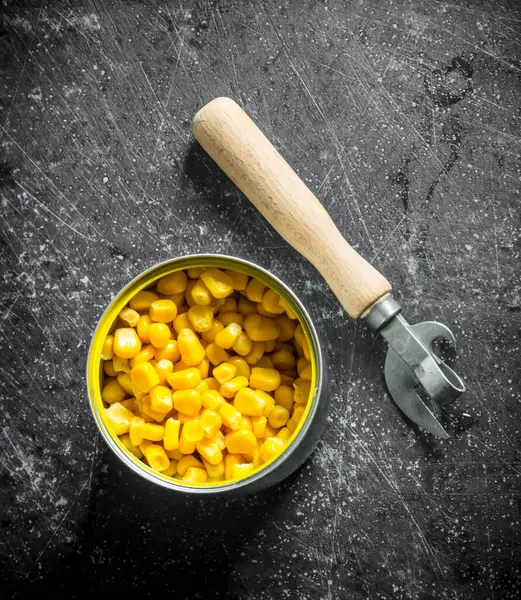 Konserve mısır ile açık konserve. Koyu rustik arka plan üzerinde