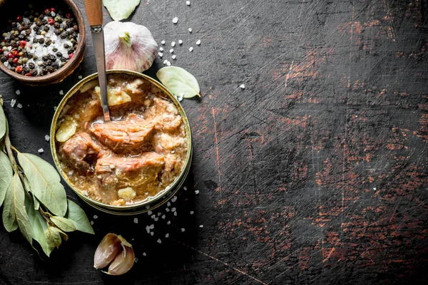 Sarımsak, baharat ve Defne yaprağı ile bir konserve et. Koyu rustik arka plan üzerinde