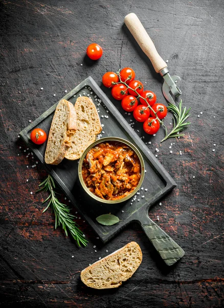 Domates, ekmek ve biberiye ile kesme Tahtası üzerinde domates sosu sprat. Koyu rustik arka plan üzerinde