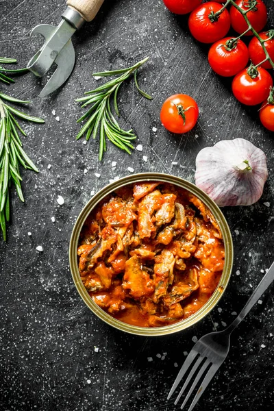 Domates soslu sprat ile açık konserve konserve. Koyu rustik arka plan üzerinde