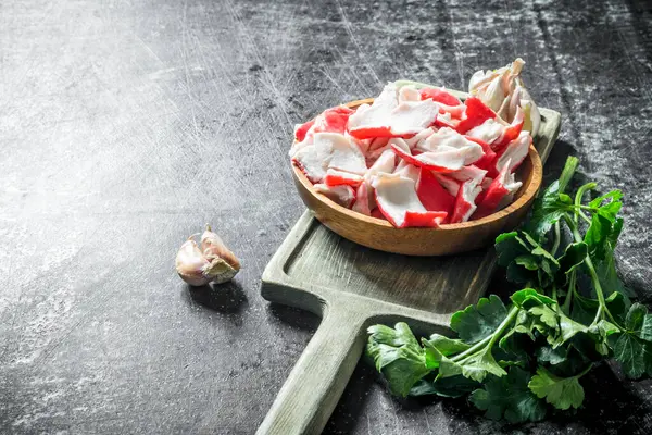 Sarımsak karanfil ve maydanoz ile doğrama Tahtası üzerinde Yengeç eti. Koyu rustik arka plan üzerinde