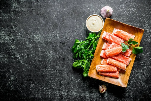 Yengeç sarımsak, otlar ve sos ile sopalarla. Koyu rustik arka plan üzerinde