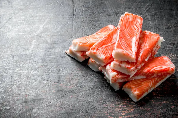 Taze yengeç çubukları. Koyu rustik arka plan üzerinde