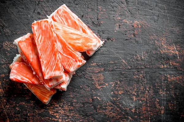 Taze yengeç çubukları. Koyu rustik arka plan üzerinde