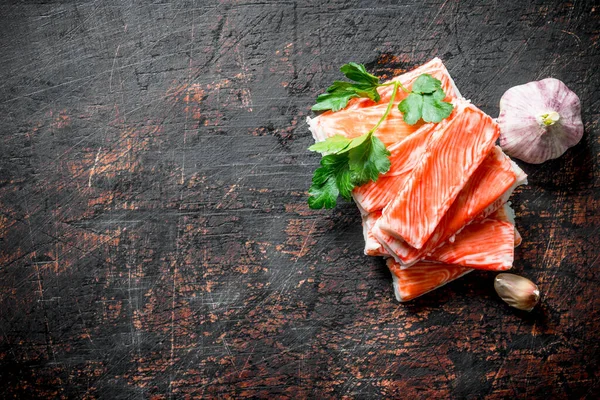 Yengeç sarımsak ve maydanozla yapışır. Koyu rustik arka plan üzerinde