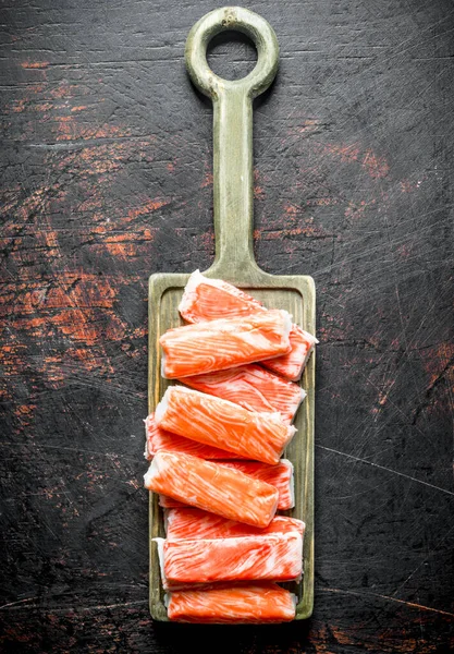 Yengeç kesme tahtasına yapışır. Koyu rustik arka plan üzerinde