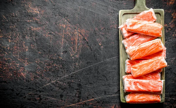 Yengeç kesme tahtasına yapışır. Koyu rustik arka plan üzerinde