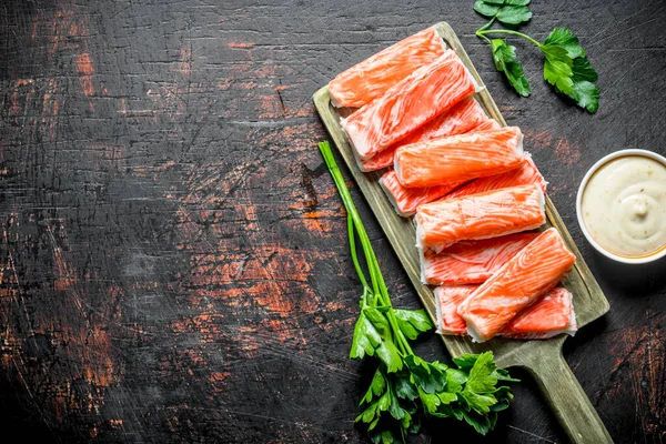 Yengeç sos ve maydanoz ile kesme Tahtası üzerinde sopalarla. Koyu rustik arka plan üzerinde