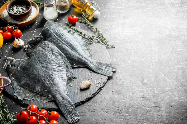 stock image Raw flounder with cherry tomatoes, spices and garlic cloves. On dark rustic background