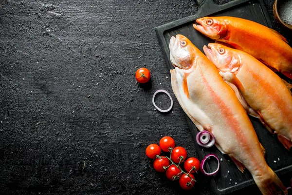 stock image Fresh raw trout with tomatoes. On black rustic background