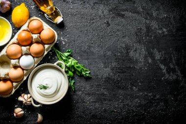 Yumurta, sarımsak ve limon ile mayonez. Siyah rustik arka plan üzerinde