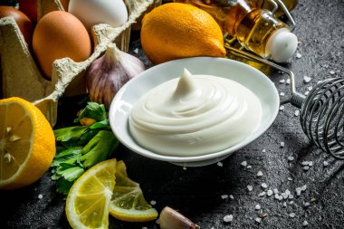 Zeytinyağı, otlar ve yumurta ile mayonez. Siyah rustik arka plan üzerinde