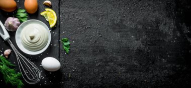 Yumurta, sarımsak ve otlar ile mayonez. Siyah rustik arka plan üzerinde