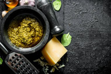 Fesleğen, yağ ve Parmesan ile bir taş Tahta üzerinde Pesto sosu. Siyah rustik arka plan üzerinde