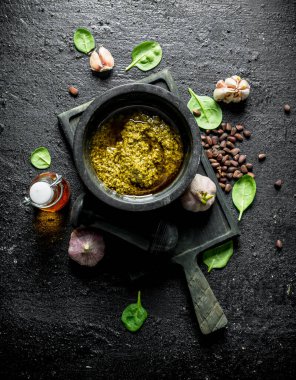 Çam fıstığı, fesleğen ve zeytinyağı ile Pesto sos. Siyah rustik arka plan üzerinde