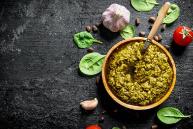 Domates, sarımsak ve Fesleğen yaprakları ile Pesto sos. Siyah rustik arka plan üzerinde
