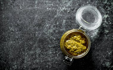 Cam bir kavanozda pesto sosu. Koyu rustik arka plan üzerinde