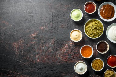 Farklı sos çeşitleri yelpazesi. Koyu rustik arka plan üzerinde