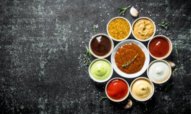 Soslu kaseler. Koyu rustik arka plan üzerinde