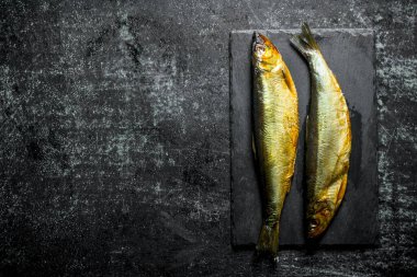 Taş tahtada füme balık. Koyu rustik arka plan üzerinde