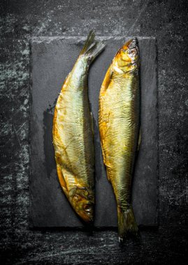 Taş tahtada füme balık. Koyu rustik arka plan üzerinde