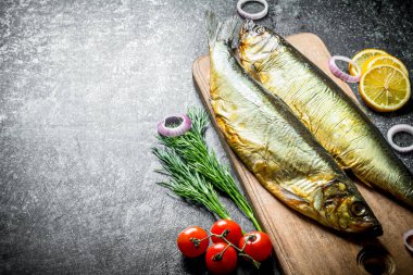 Domates, dereotu ve limon dilimleri ile ahşap kesme Tahtası üzerinde Füme balık. Koyu rustik arka plan üzerinde