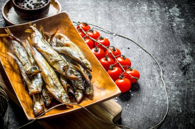 Domates ve baharatile füme balık. Koyu rustik arka plan üzerinde