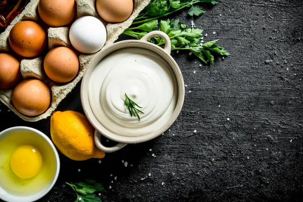 stock image Mayonnaise with parsley, eggs and lemon. On black rustic background