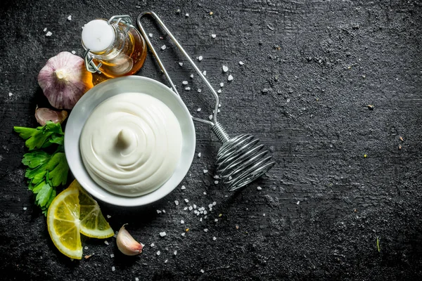 Maydanoz, zeytinyağı ve limon dilimleri ile mayonez. Siyah rustik arka plan üzerinde