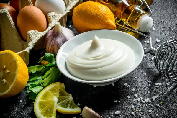 Zeytinyağı, otlar ve yumurta ile mayonez. Siyah rustik arka plan üzerinde