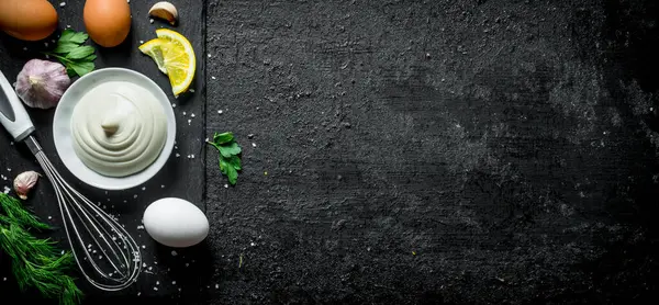 Yumurta, sarımsak ve otlar ile mayonez. Siyah rustik arka plan üzerinde