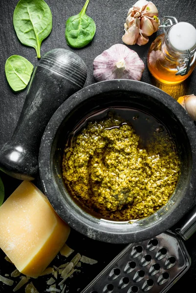 Fesleğen, yağ ve Parmesan ile bir taş Tahta üzerinde Pesto sosu. Siyah rustik arka plan üzerinde