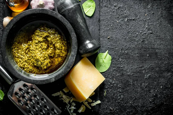 Fesleğen, yağ ve Parmesan ile bir taş Tahta üzerinde Pesto sosu. Siyah rustik arka plan üzerinde