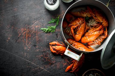 Tencerede haşlanmış kerevit. Koyu rustik arka plan üzerinde
