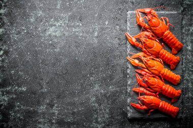 Taş tahtada pişmiş kerevit. Koyu rustik arka plan üzerinde