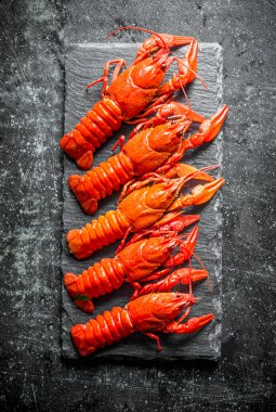 Taş tahtada pişmiş kerevit. Koyu rustik arka plan üzerinde