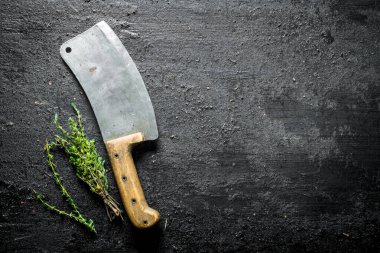 Büyük bir bıçaklı kekik. Siyah rustik arka plan üzerinde