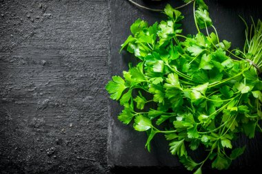 Yararlı otlar. Taze maydanoz. Siyah rustik arka plan üzerinde