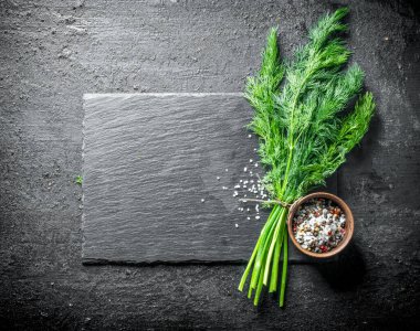 Baharatlı bir demet taze dereotu. Siyah rustik arka plan üzerinde